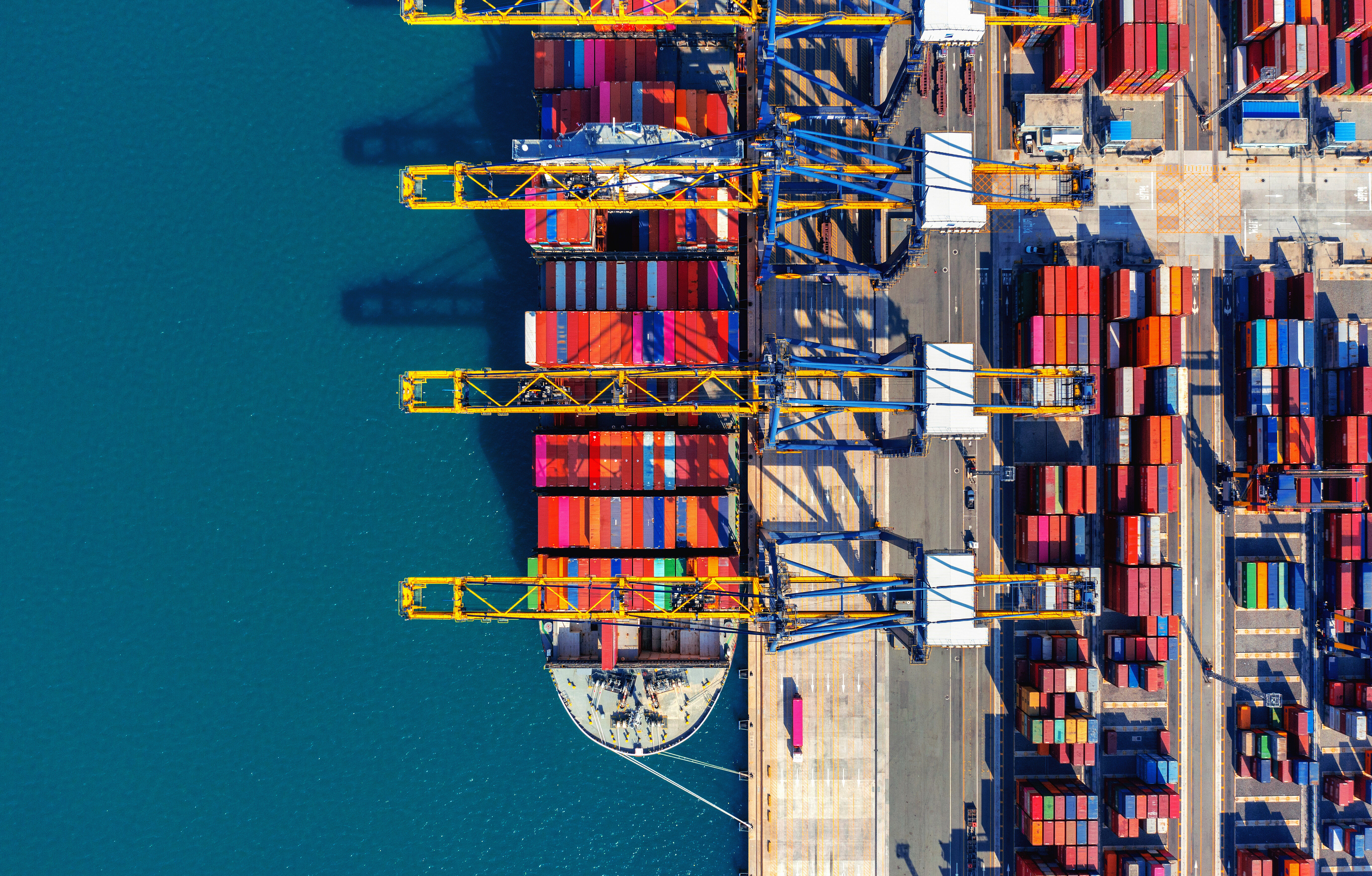 Aerial view of cargo ship and cargo container in harbor.